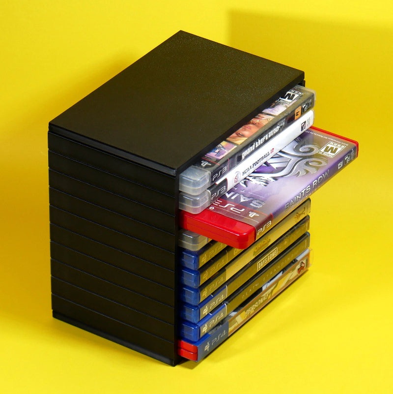 A black PlayStation 3 console with several game cases partially pulled out from the front, set against a bright yellow background.